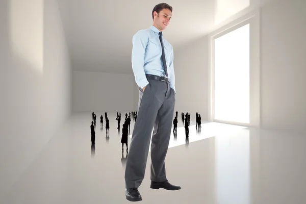 Immagine composita di uomo d'affari felice in piedi con le mani in tasca — Foto Stock