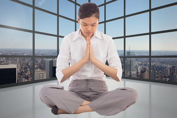 Samengestelde afbeelding van zakenvrouw zitten in lotus pose — Stockfoto