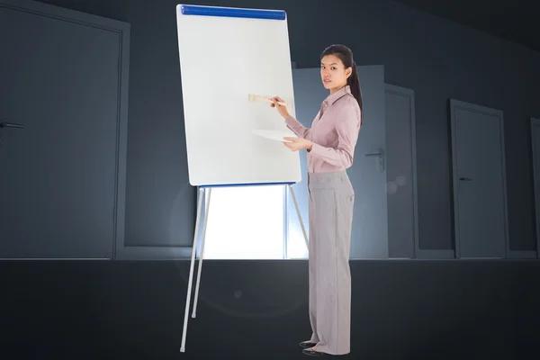 Samengestelde afbeelding van zakenvrouw schilderen op een ezel — Stockfoto