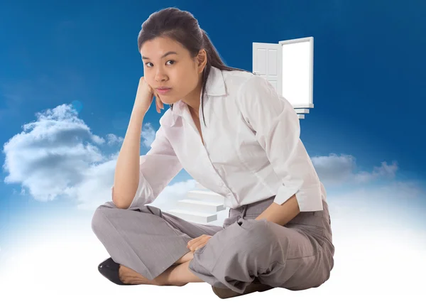 Composite image of businesswoman sitting cross legged — Stock Photo, Image