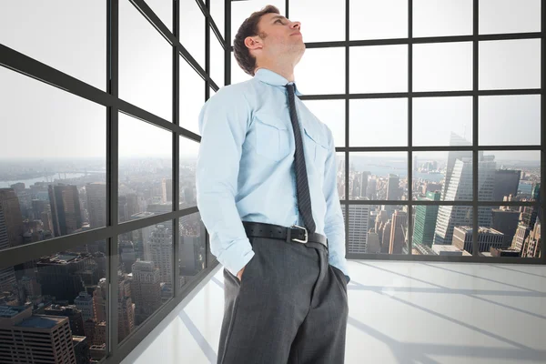 Composite image of serious businessman standing with hands in po — Stock Photo, Image