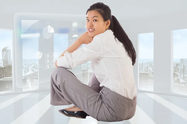 Композитный образ деловой женщины, сидящей со скрещенными ногами, улыбающейся — стоковое фото