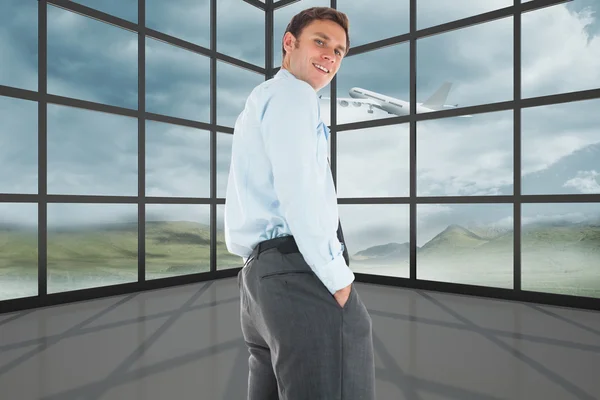 Imagen compuesta de hombre de negocios feliz de pie con las manos en la paleta — Foto de Stock