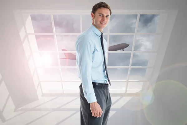 Imagen compuesta de un hombre de negocios sonriente de pie con la mano en poc —  Fotos de Stock