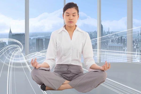 Composite image of businesswoman sitting in lotus pose — Stock Photo, Image