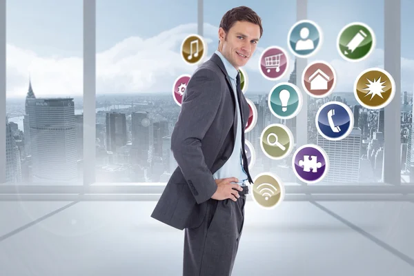 Composite image of smiling businessman with hands on hips — Stock Photo, Image