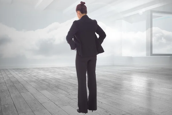 Composite image of businesswoman with hands on hips — Stock Photo, Image