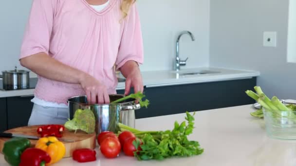 Vrouw groenten ingebruikneming een pan — Stockvideo