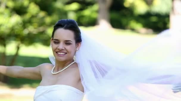 Beautiful bride smiling at camera in the park — Stock Video