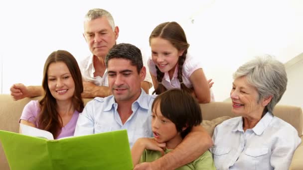 Familia extendida mirando álbum de fotos juntos — Vídeo de stock