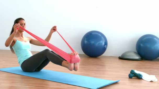 Passar brunett stretching med resitance bandet i studion — Stockvideo