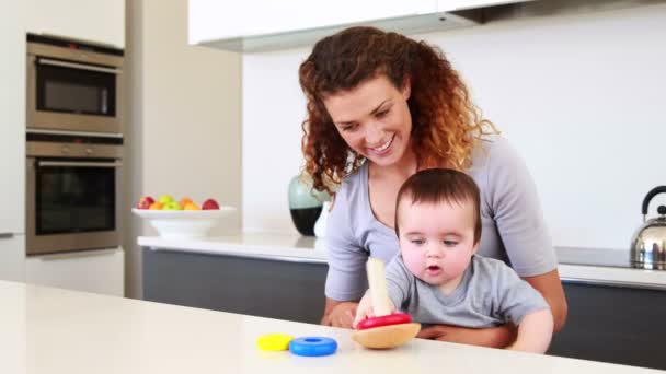 Mutlu anne bebek çocuk ile tahta oyuncakla oynamak kucağına oturmuş — Stok video