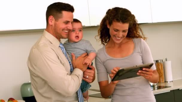 Parents using tablet pc while father holds baby — Stock Video