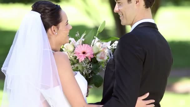 Felices recién casados de pie en el parque — Vídeos de Stock