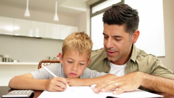 Vader helpt zijn zoon met zijn huiswerk — Stockvideo