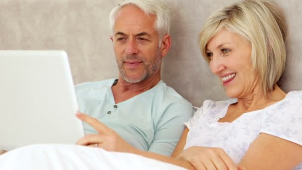 Casal feliz conversando e usando laptop na cama — Vídeo de Stock