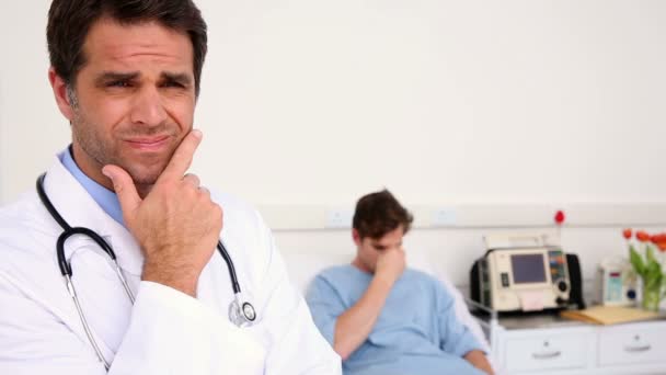 病気の男の顔をしかめ医者と病院のベッドに横たわっています。 — ストック動画