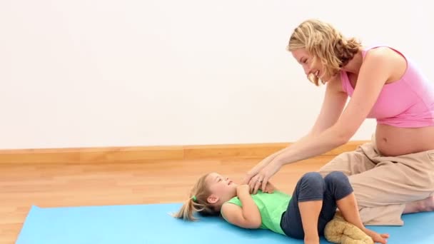 Blonde pregnant woman tickling her little girl — Stock Video