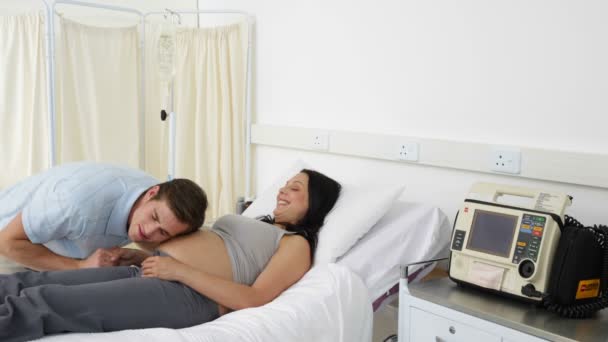 Morena mujer embarazada acostada en la cama hablando con su pareja — Vídeo de stock
