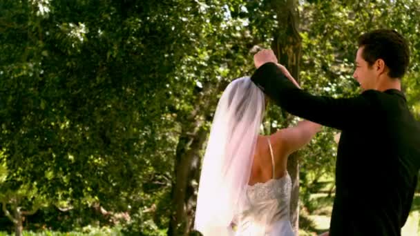 Happy newlywed couple dancing in the park — Stock Video