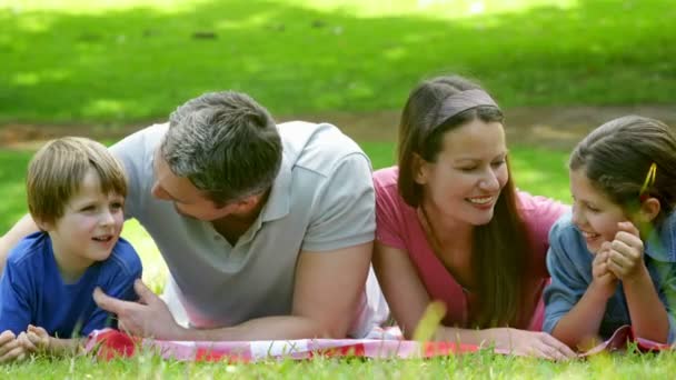 Söta familjen ligga på en filt i parken — Stockvideo