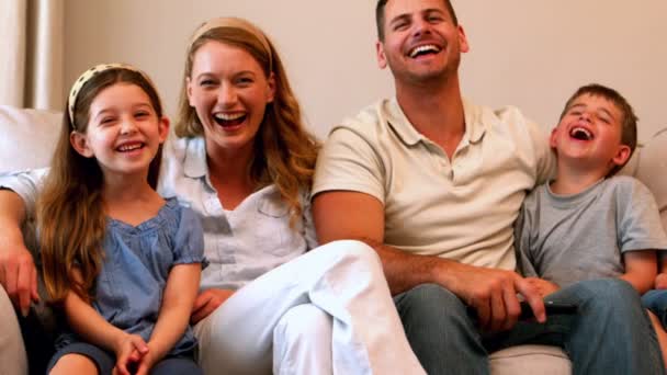 Genç aile kanepede gülüyor — Stok video