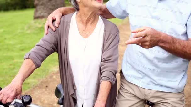 Pensionerat par i parken ridning deras cyklar — Stockvideo