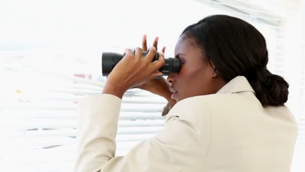 Businesswoman looking through blinds with binoculars — Stock Video