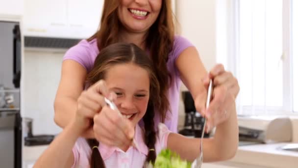 Mother showing her cute daughter how to toss a salad — Stock Video