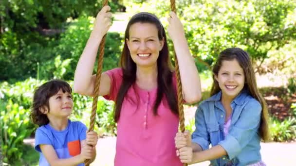 Crianças empurrando sua mãe em um balanço — Vídeo de Stock