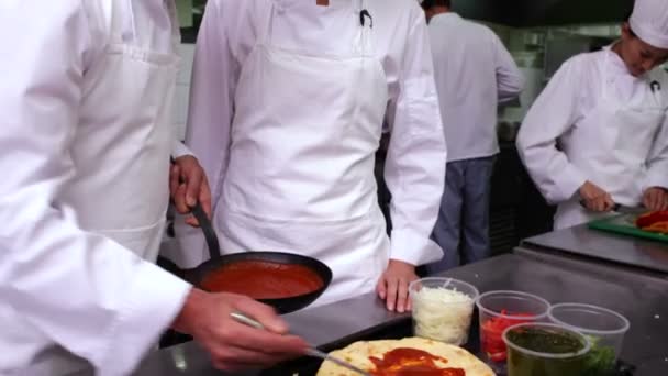 Chefe de cozinha mostrando outro como fazer pizza — Vídeo de Stock