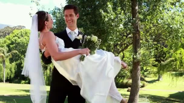 Sposo raccogliendo la sua bella nuova moglie — Video Stock