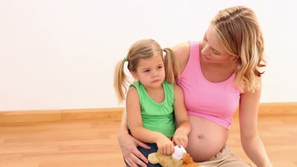 Mujer embarazada rubia sentada con su niña — Vídeos de Stock