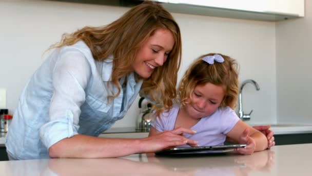 Moeder met behulp van Tablet PC met haar dochter in de keuken — Stockvideo