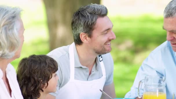 Familia hablando juntos en la mesa de picnic — Vídeos de Stock