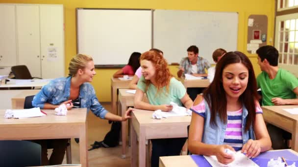 Studenti che ridono lanciando carta in classe — Video Stock