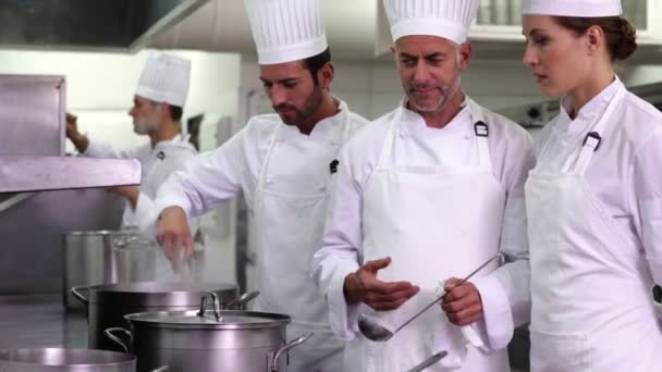 Chef showing colleague content of pot — Stock Video