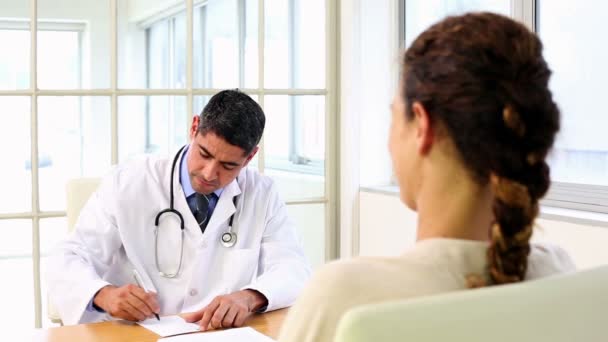 Doctor speaking with his sick patient at desk — Stock Video