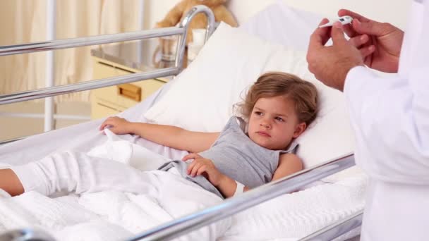 Красивый врач проверяет температуру маленькой девочки — стоковое видео