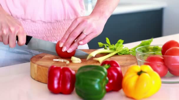 Vrouw snijden tomaat op een snijplank — Stockvideo