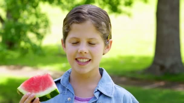 Schattig klein meisje watermeloen eten in het park — Stockvideo