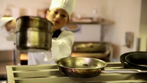 Gelukkig chef-kok nemen potten en pannen uit een plank — Stockvideo