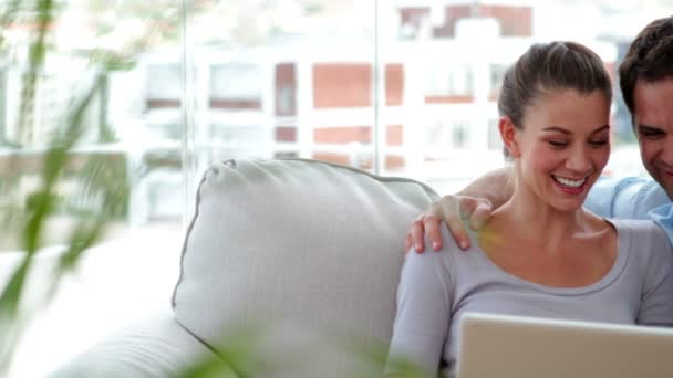 Par avkopplande på soffan med laptop — Stockvideo