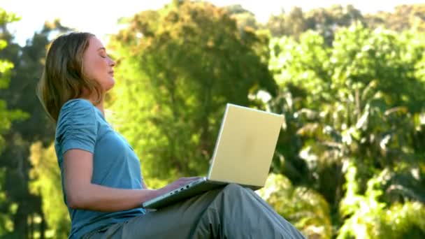 Junge Frau benutzt Laptop im Park — Stockvideo