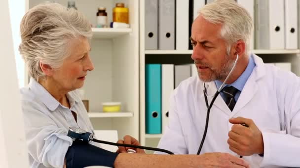 Doctor tomando la presión arterial de su paciente — Vídeos de Stock