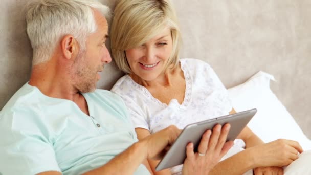 Casal conversando e usando tablet na cama — Vídeo de Stock