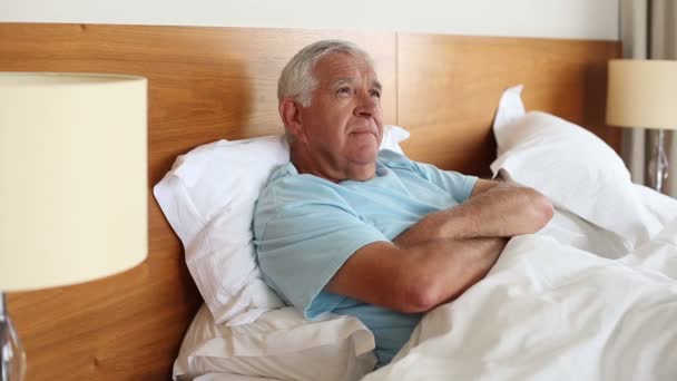 Senior man lying in bed thinking — Stock Video