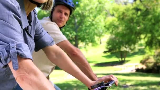 Happy couple going for a bike ride in the park — Stock Video