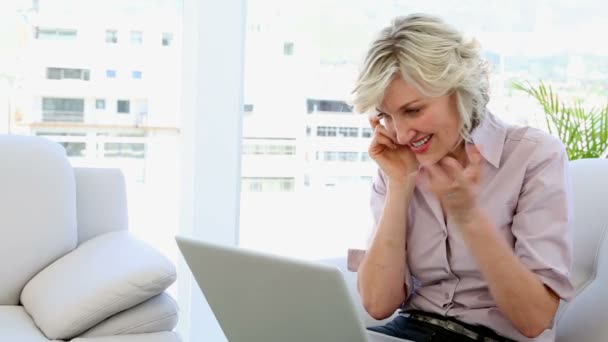 Femme d'affaires parlant au téléphone et utilisant un ordinateur portable — Video