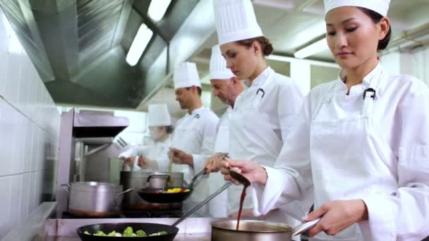 Chef revolviendo salsa sonriendo a la cámara — Vídeos de Stock